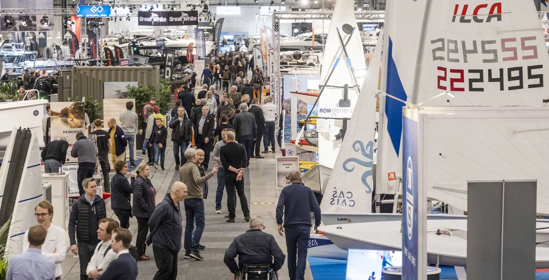 Ställa ut på Allt för sjön: Överblick över välbesökt mässgång fylld med båtar och montrar.
