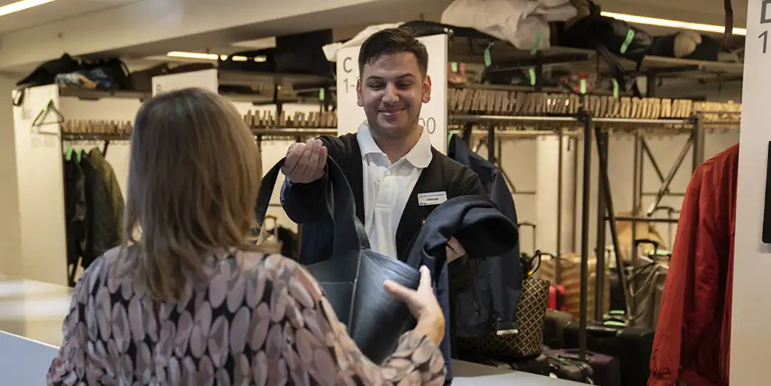 Personal i garderoben på Stockholmsmässan hjälper en besökare under båtmässan Allt för Sjön.