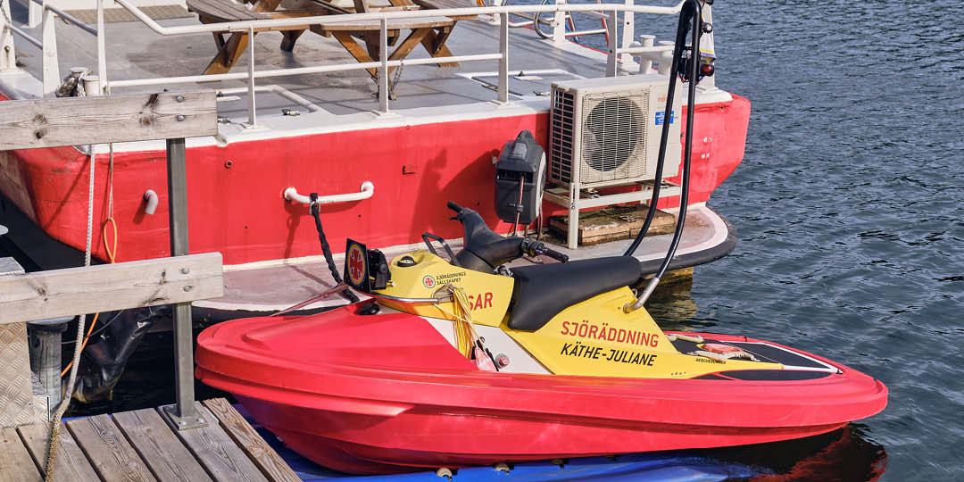 Bakifrån syns en räddningsbåt med en räddningsjetski upplyft på bryggan