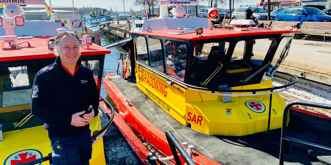 Man som står vid sjöräddningsbåt